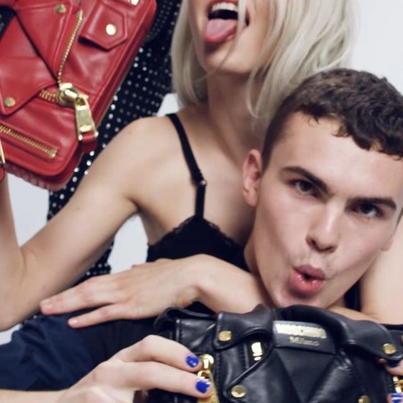 Models posing with red and black Moschino Biker Bags in a fashion campaign.